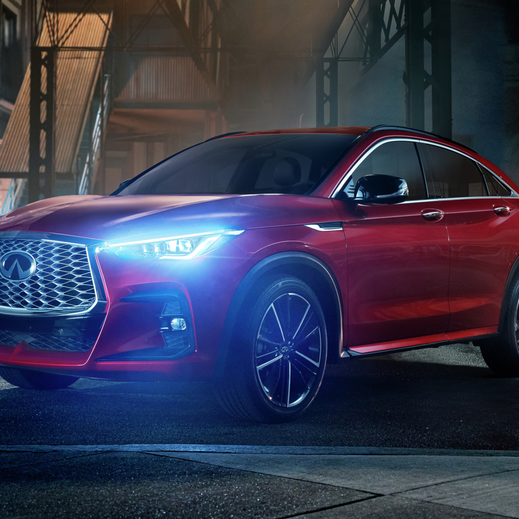 Красный автомобиль Infiniti QX55 AWD, 2022 года с включенными фарами