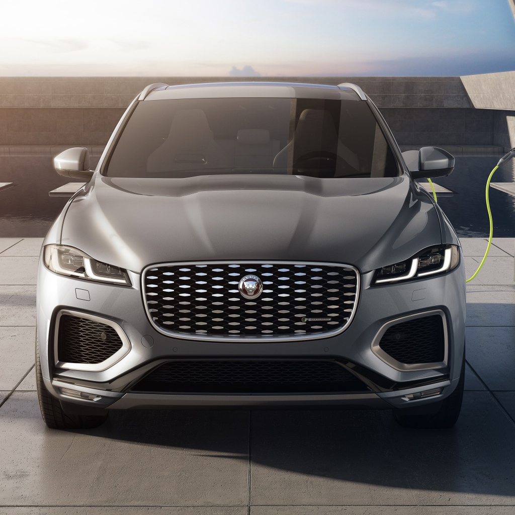 Серый автомобиль Jaguar F-Pace P400e AWD 2020 года на заправке