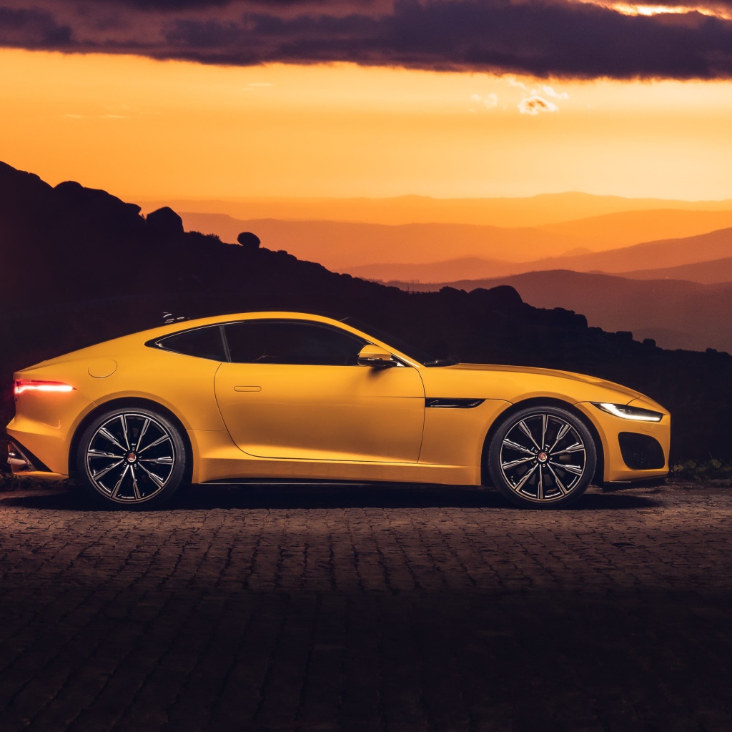 Желтый автомобиль jaguar f type 2020 года на закате 