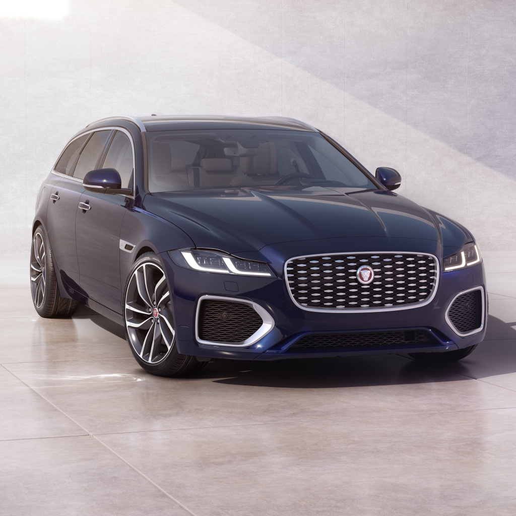 Синий автомобиль Jaguar XF Sportbrake 2020 года у стены 