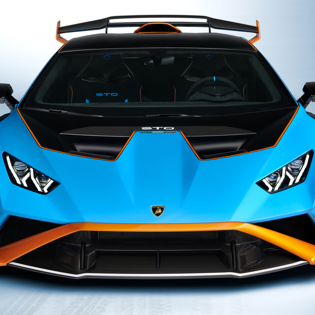 Голубой автомобиль Lamborghini Huracán STO 2021 года вид спереди на сером фоне