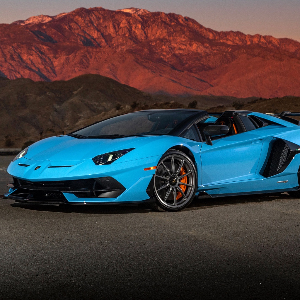 Голубой спортивный автомобиль Lamborghini Aventador SVJ Roadster, 2020 года на фоне гор