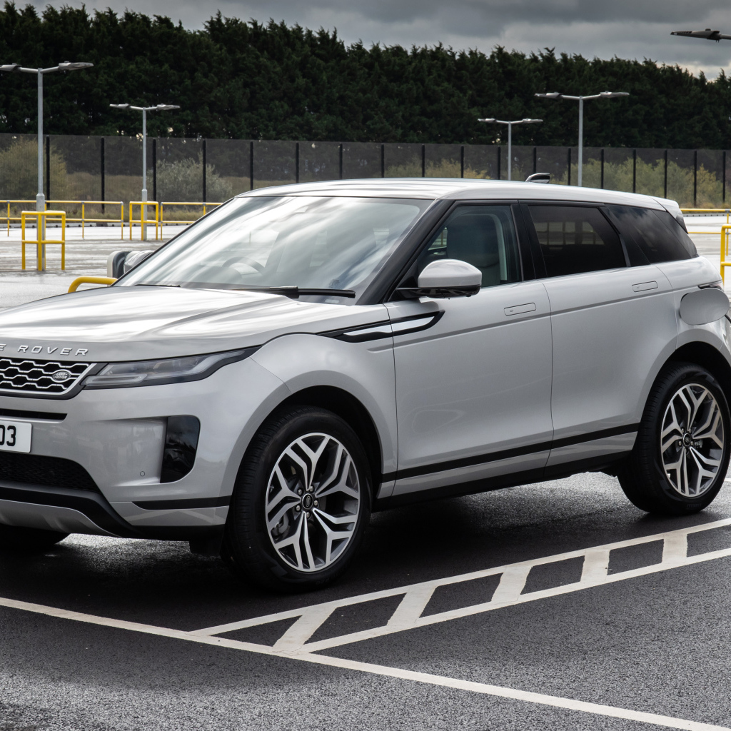 Серебристый автомобиль Range Rover Evoque P300e S 2020 года на заправке