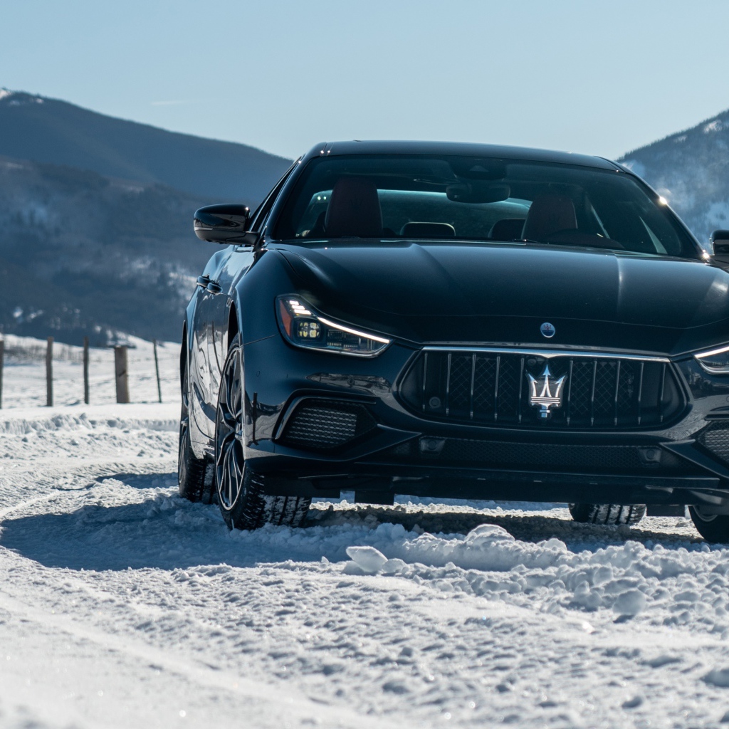 Черный автомобиль Maserati Ghibli S Q4, 2020 года едет по заснеженной дороге