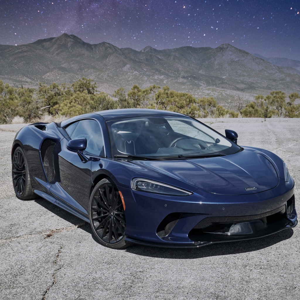 Черный автомобиль  McLaren GT, 2020 года под звездным небом