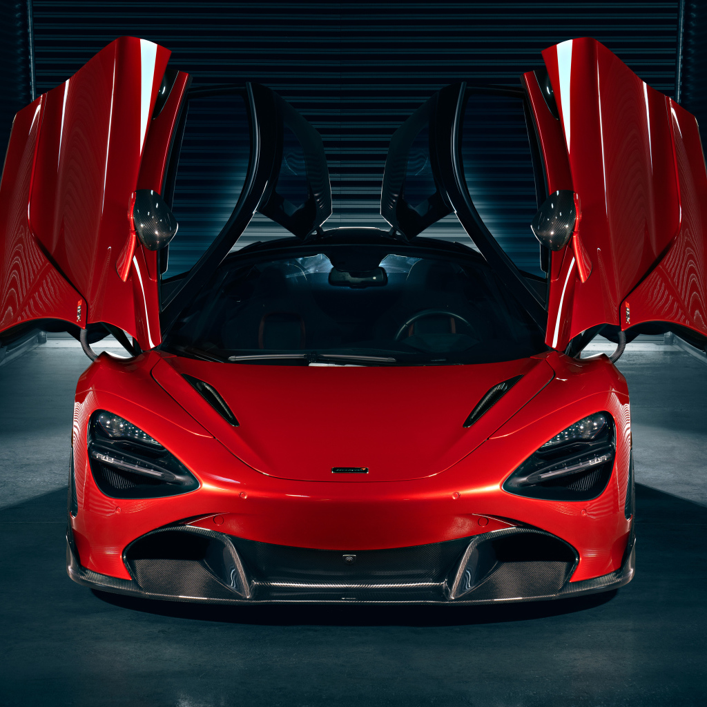 Красный автомобиль McLaren 720S с открытыми дверями в гараже