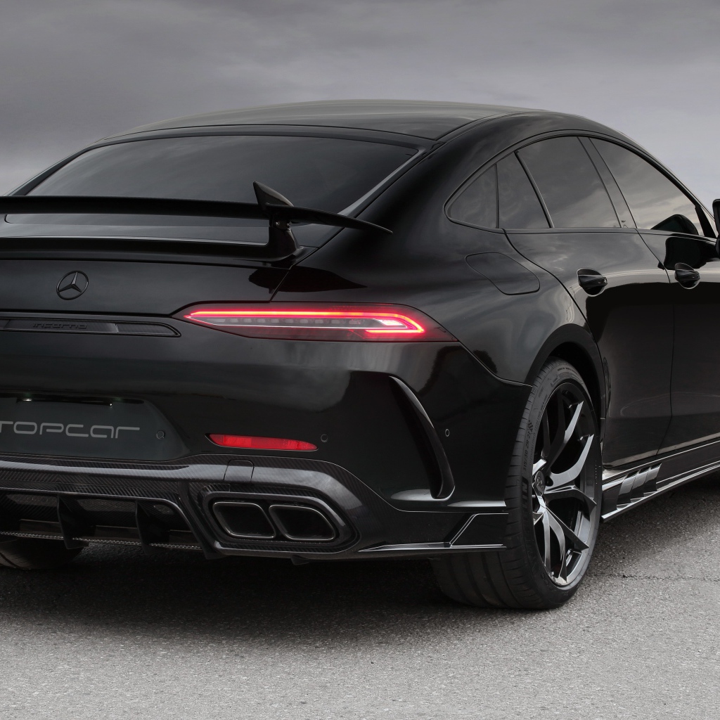 Черный автомобиль Mercedes-AMG GT 63 S 4MATIC+, 2020 года вид сзади на сером фоне