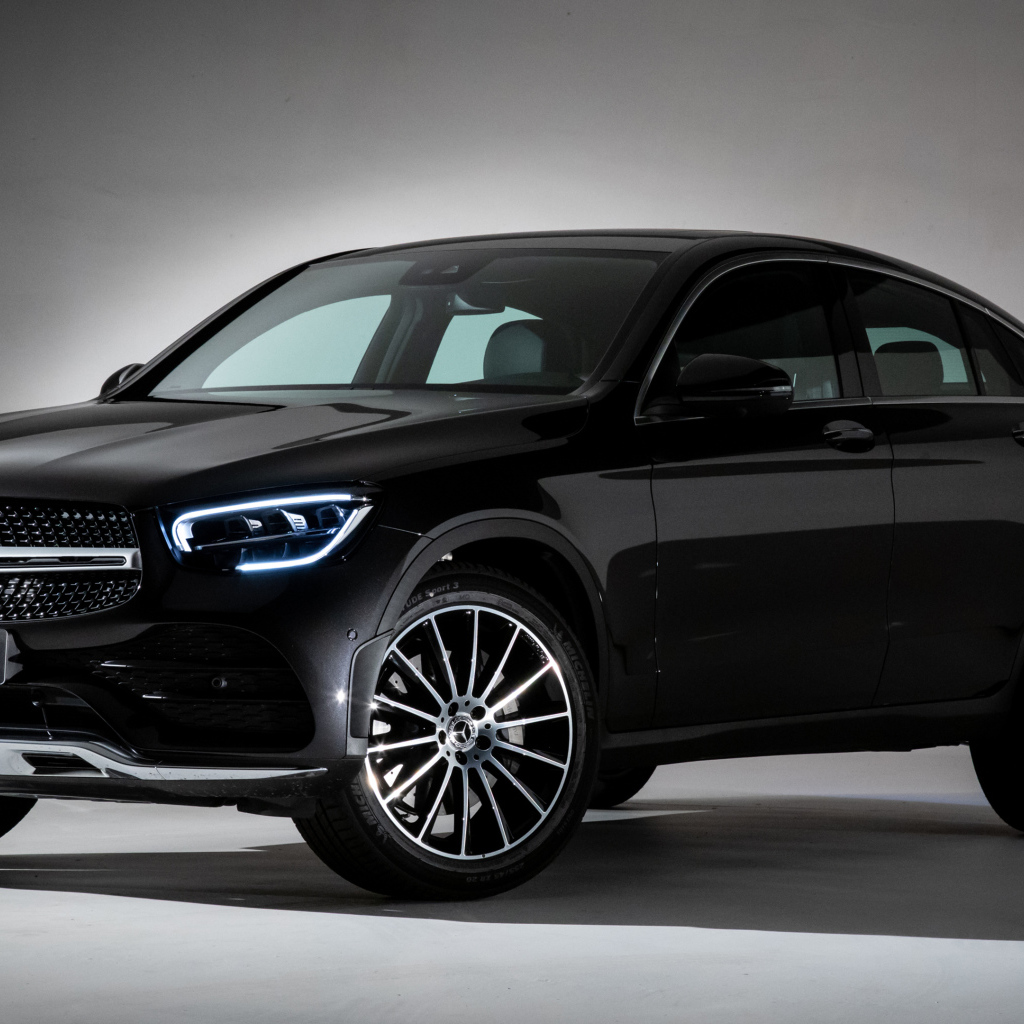 Черный стильный автомобиль Mercedes-Benz GLC 300,  2019 года на сером фоне