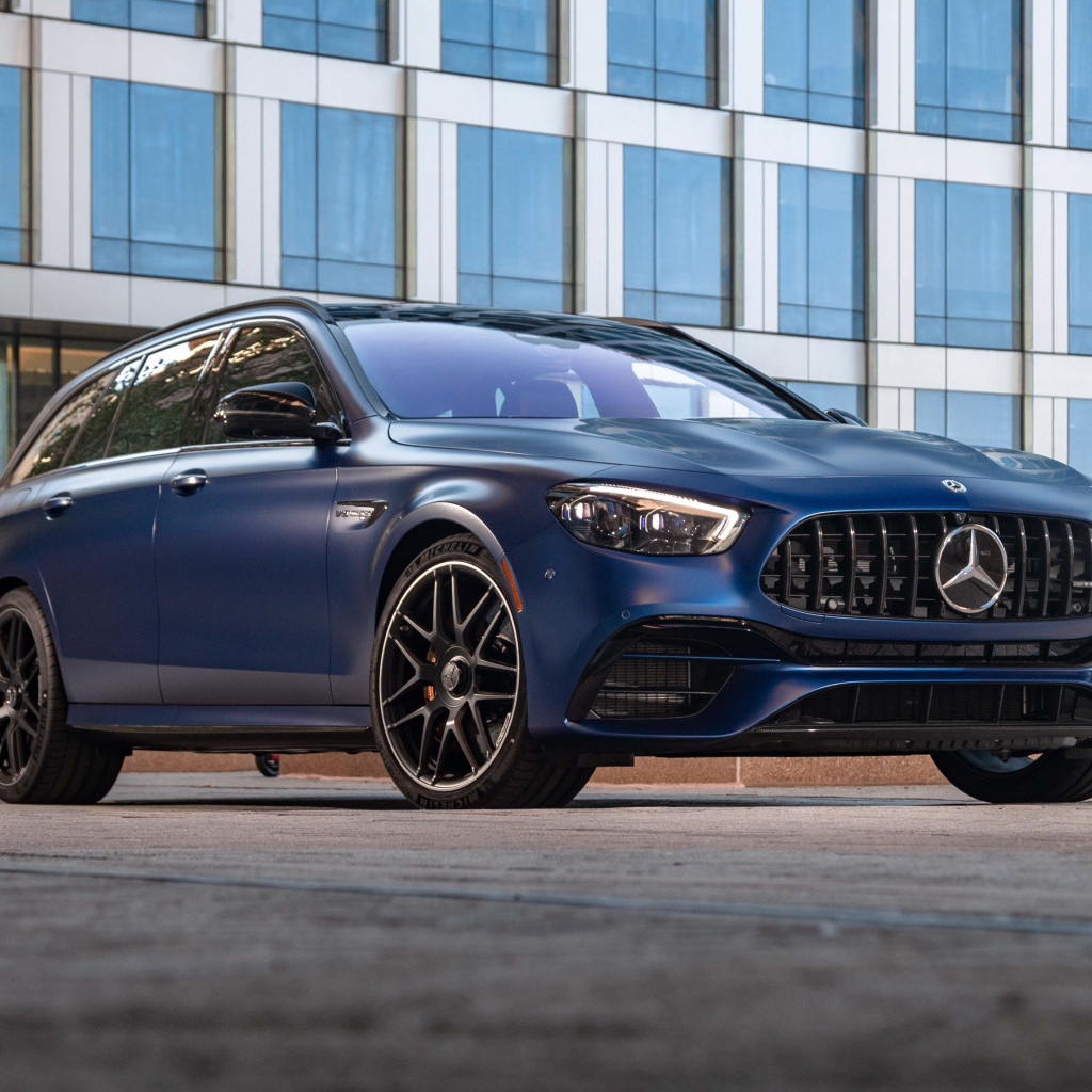 Синий автомобиль Mercedes-AMG E 63 S 4MATIC+, 2021 года на фоне дома