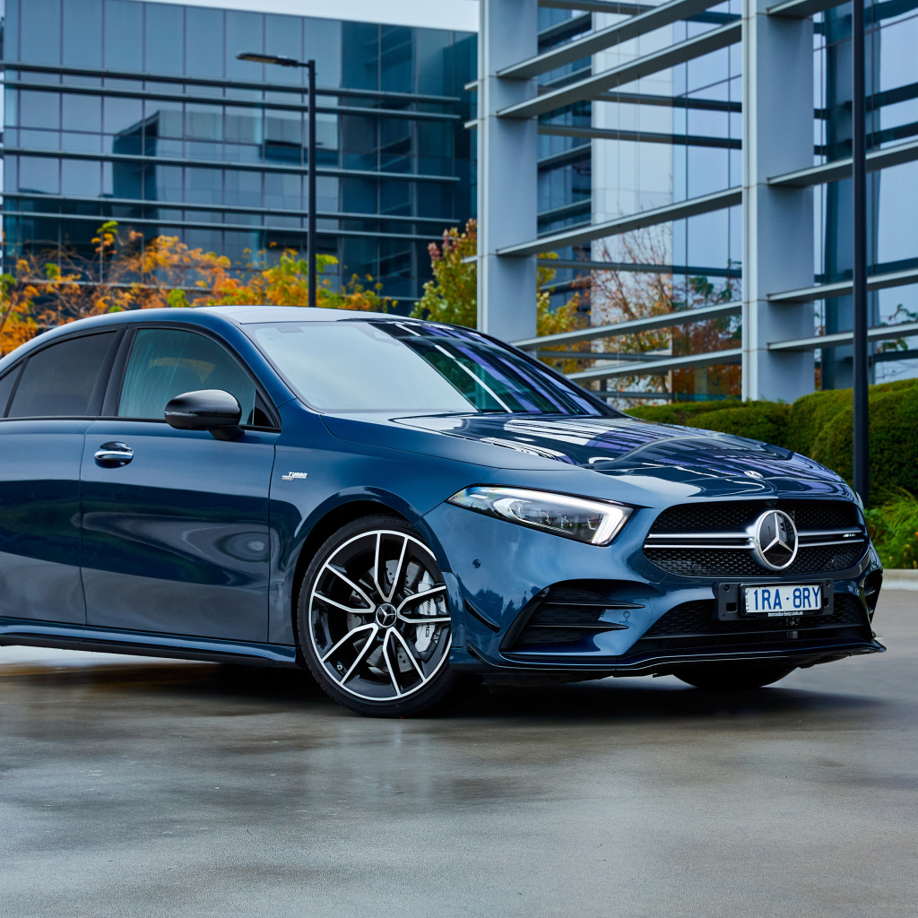 Синий автомобиль Mercedes-Benz AMG A 35, 2020 года на фоне здания 