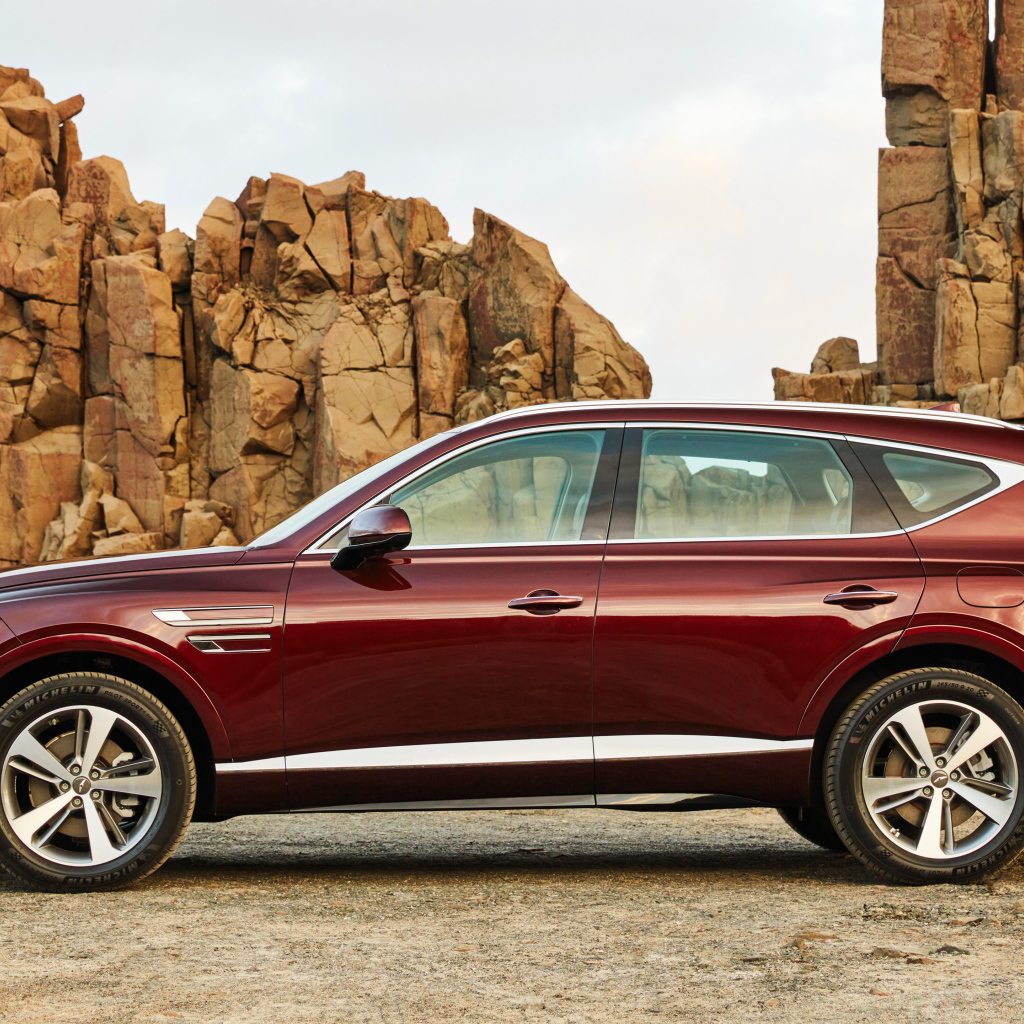 Бордовый автомобиль Genesis GV80 2.5T 2020 года на фоне гор