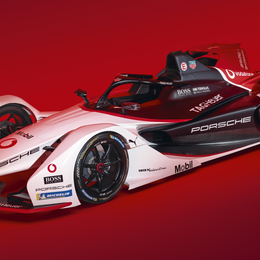 Гоночный автомобиль Porsche 99X Electric 2019 года на красном фоне