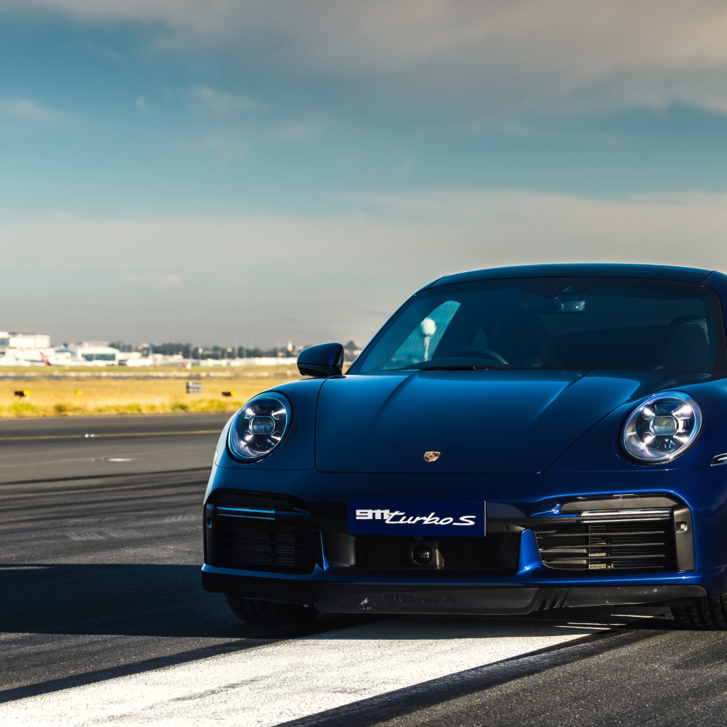 Синий автобус Porsche 911 Turbo S 2020 года на трассе