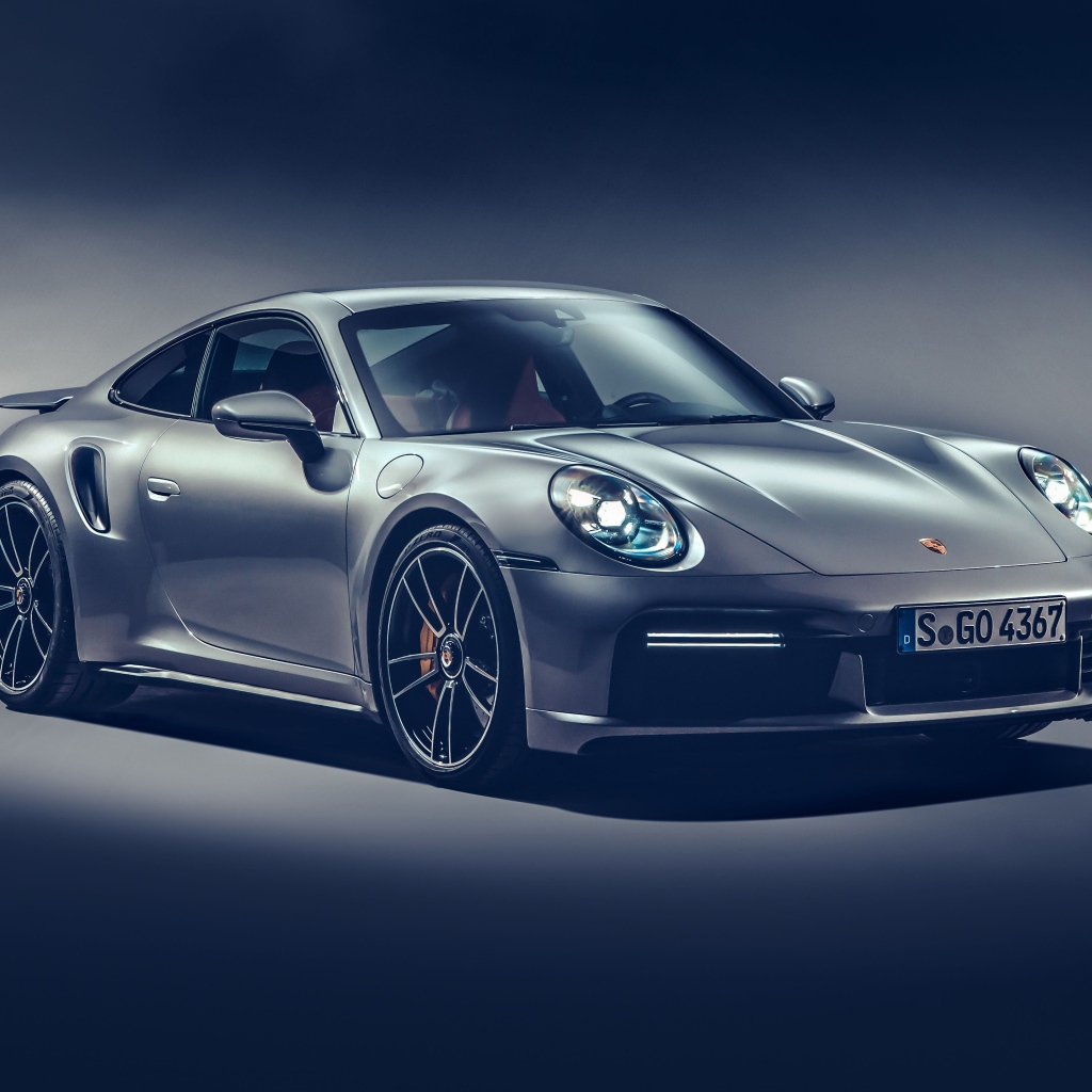 Автомобиль Porsche 911 Turbo S 2020 года на сером фоне