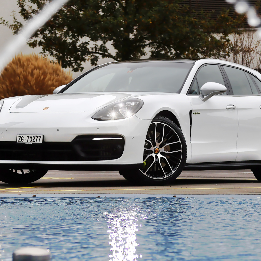 Белый автомобиль Porsche Panamera 4S E-Hybrid Sport Turismo 2020 года у бассейна