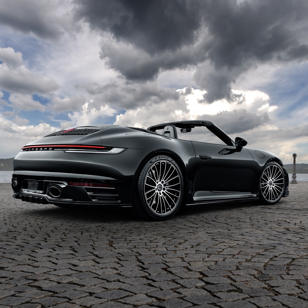 Черный автомобиль Porsche 911 Carrera 4S Cabriolet 2020 года под грозовым небом