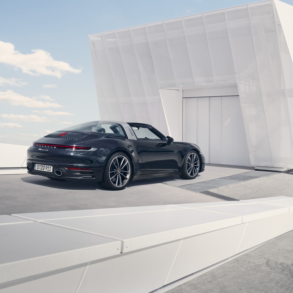 Черный автомобиль Porsche 911 Targa 4S 2020 года у гаража 