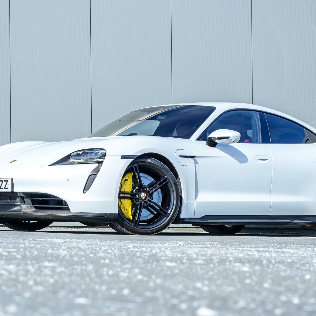 Белый автомобиль Porsche Taycan Turbo S 2020 года в лучах солнца 