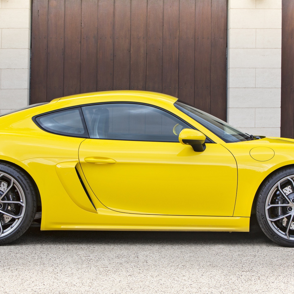 Желтый автомобиль Porsche 718 Cayman GT4 2020 года вид сбоку