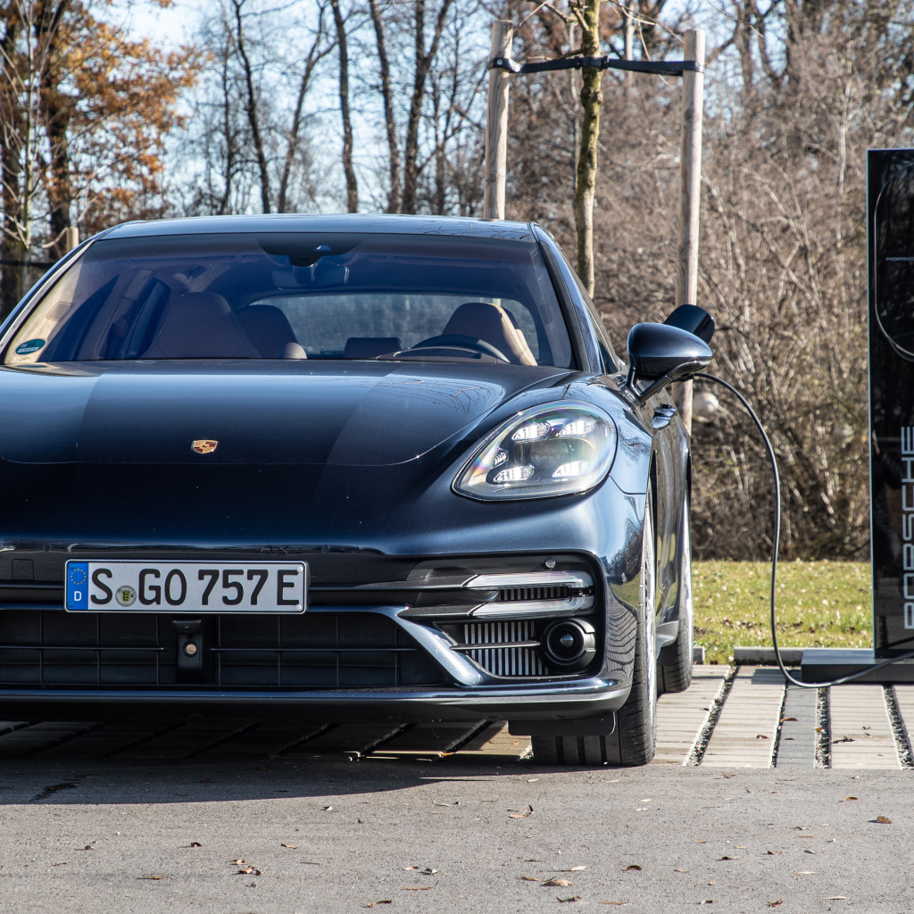 Черный автомобиль Porsche Panamera Turbo S E-Hybrid Sport Turismo 2021 года на заправке