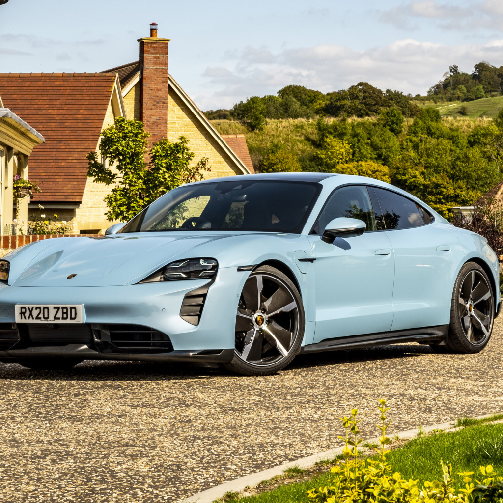 Голубой автомобиль Porsche Taycan 4S 2021 года у дома вид спереди