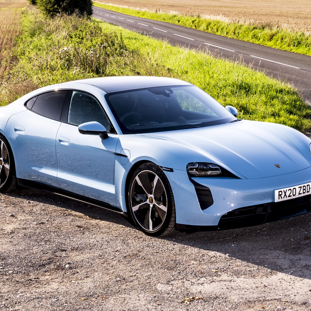 Быстрый автомобиль Porsche Taycan 4S 2021 года на фоне поля