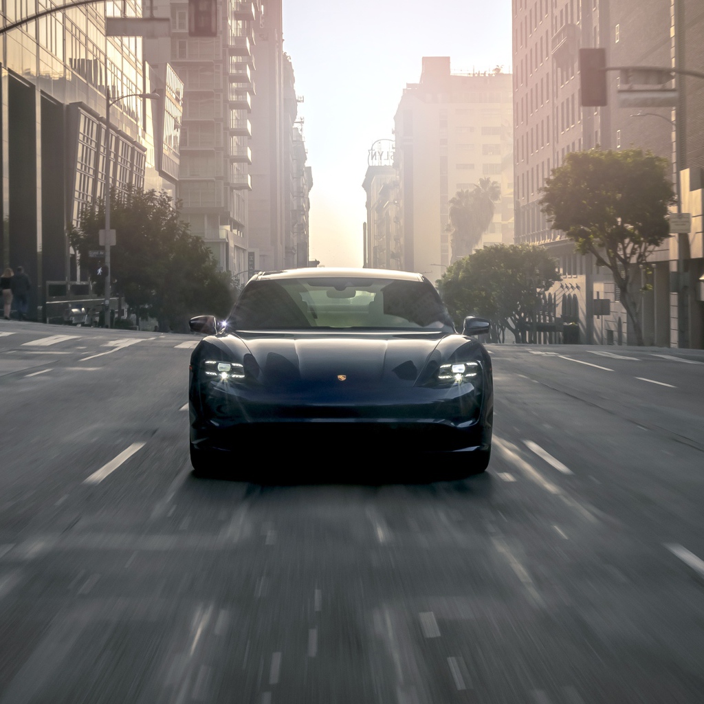 Черный стильный автомобиль  Porsche Taycan Turbo, 2020 года на дороге в городе