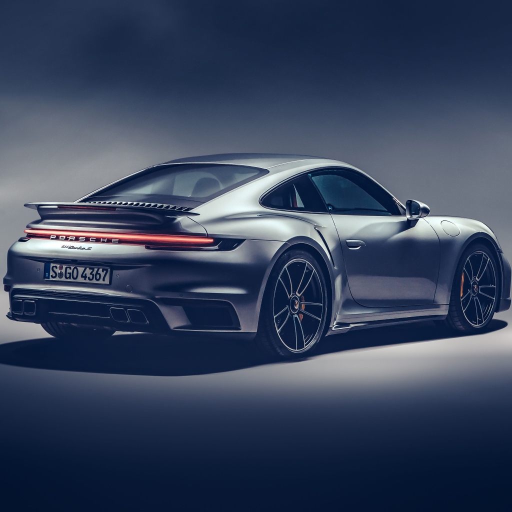 Автомобиль Porsche 911 Turbo S 2020 года на сером фоне вид сзади