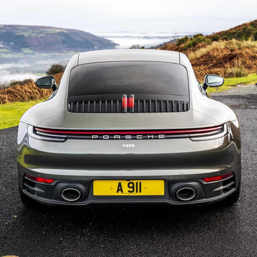 Автомобиль Porsche 911 Carrera на дороге у обрыва