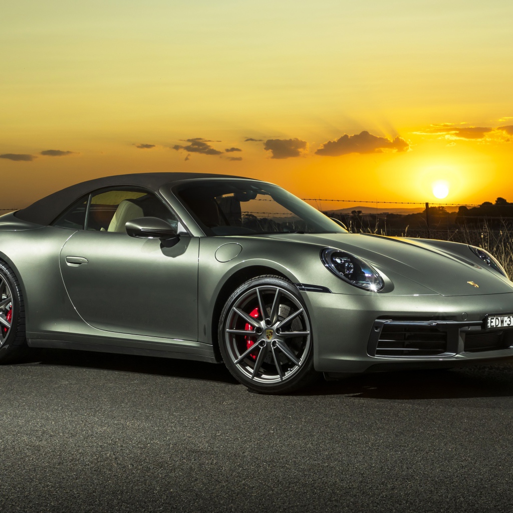 Серебристый Porsche 911 Carrera S Cabriolet 2020 года на закате 
