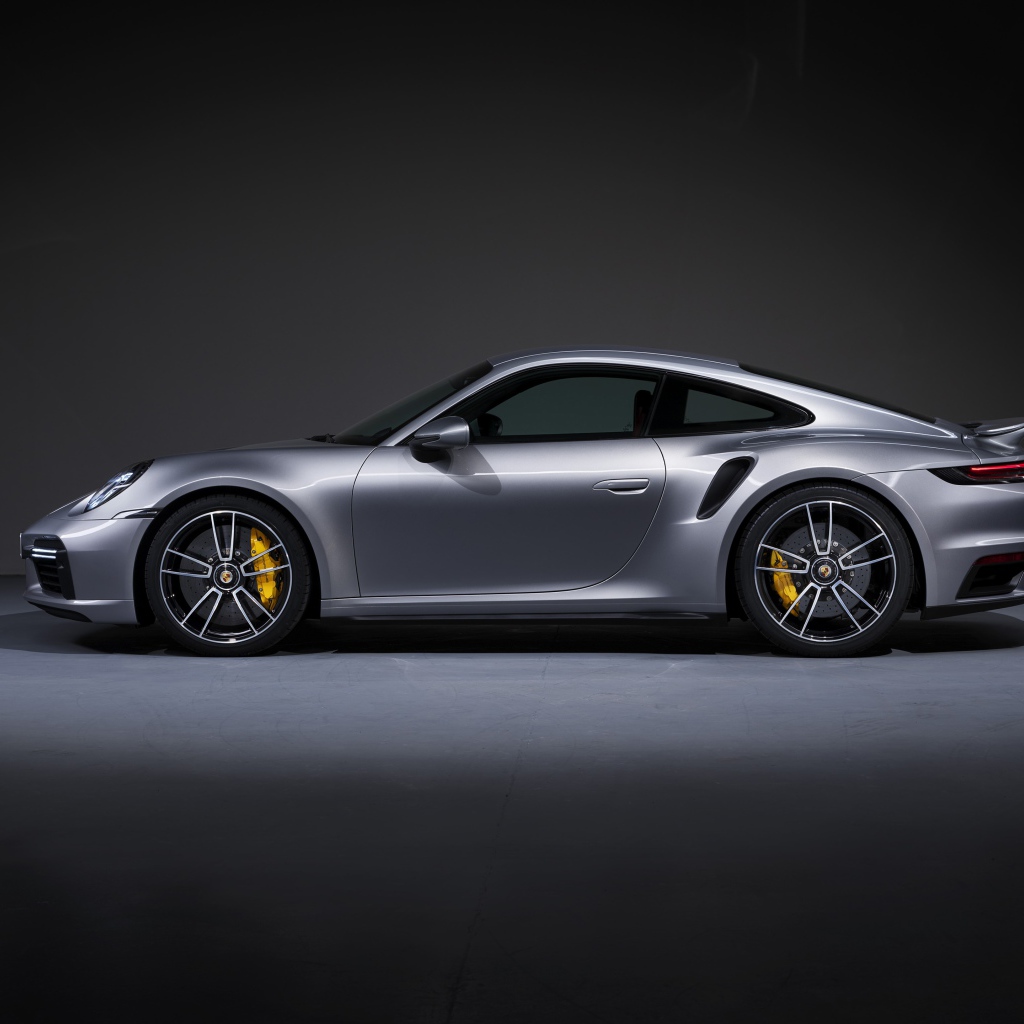 Серебристый автомобиль Porsche 911 Turbo S 2020 года вид сбоку 