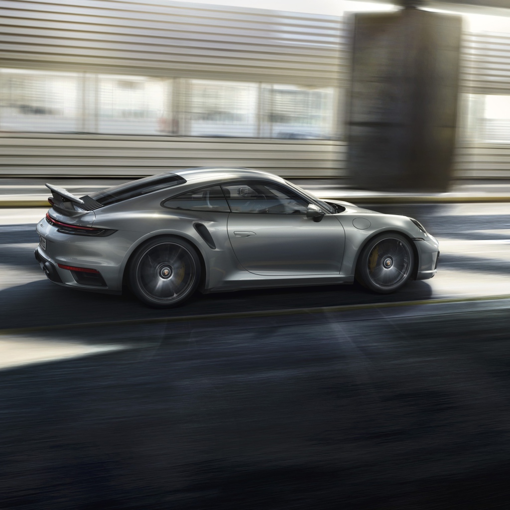 Серебристый автомобиль Porsche 911 Turbo S 2020 года на трассе 