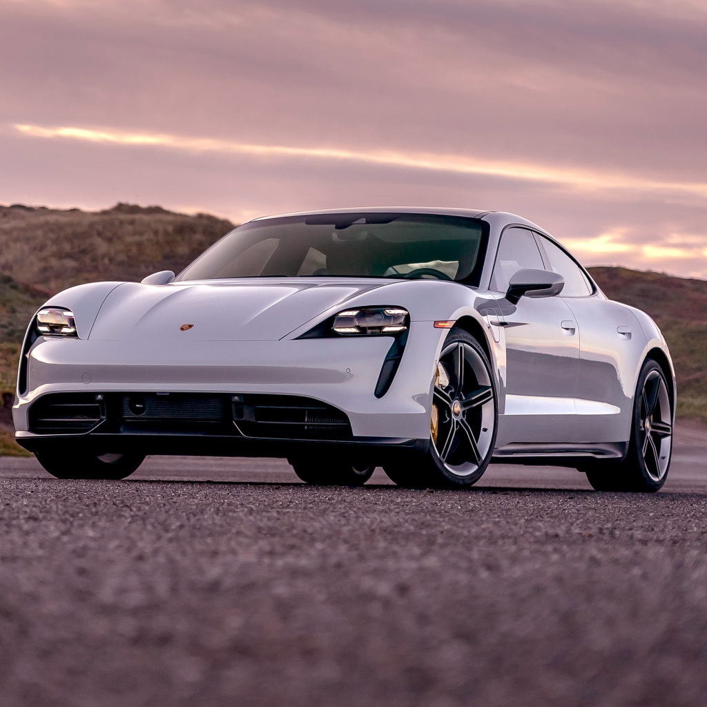 Серебристый автомобиль Porsche Taycan Turbo S 2020 года на фоне неба