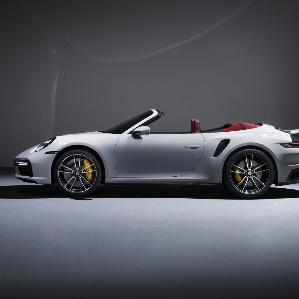 Белый автомобиль Porsche 911 Turbo S Cabriolet 2020 года на сером фоне