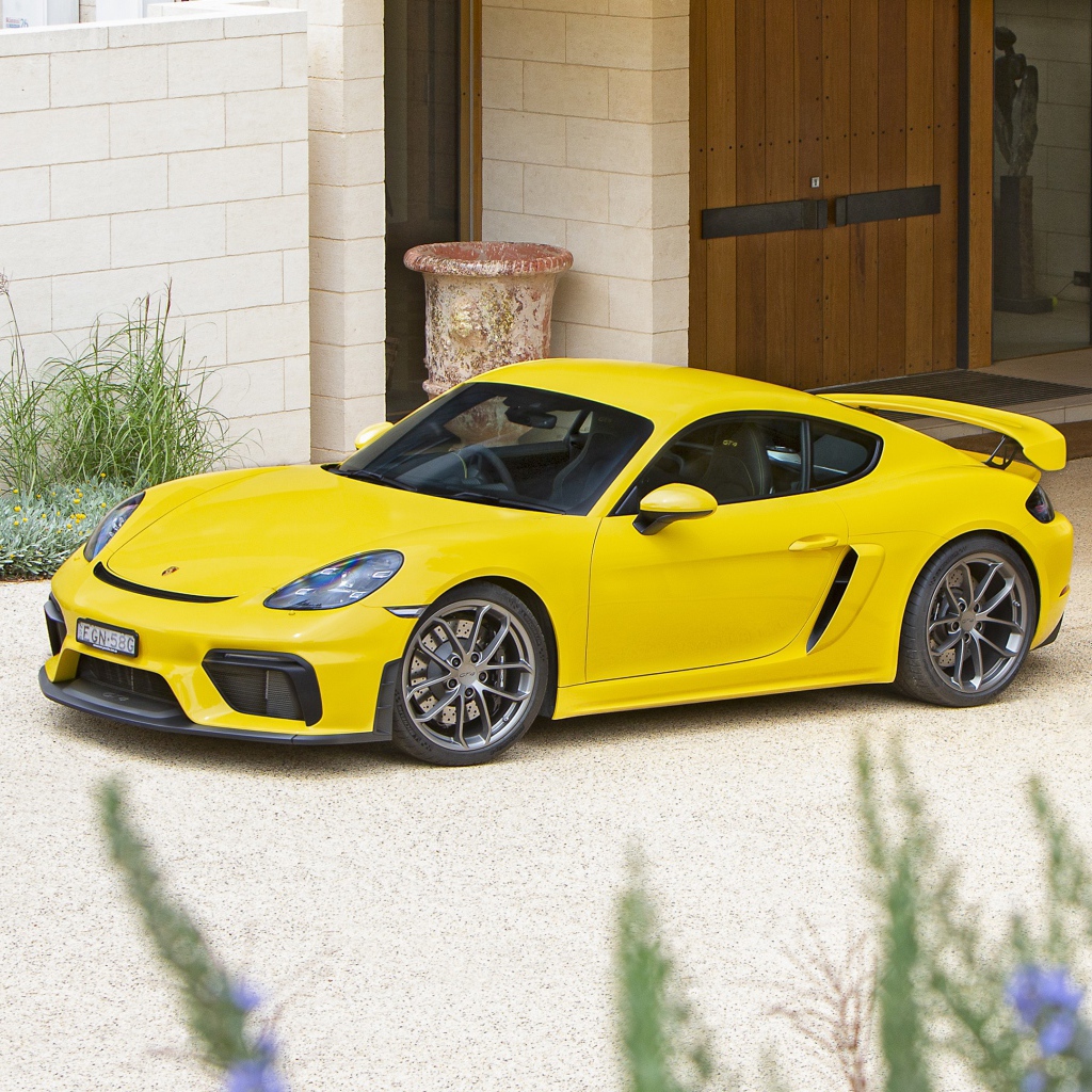 Желтый автомобиль Porsche 718 Cayman GT4,  2020 года