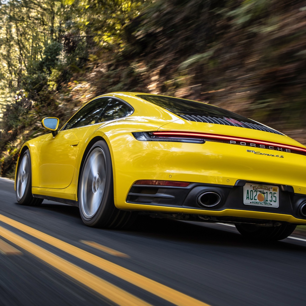 Желтый автомобиль  Porsche 911 Carrera 4S, 2020 года на трассе 