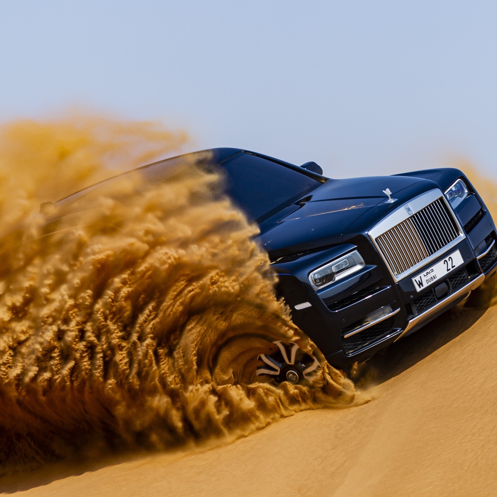 Черный Rolls-Royce Cullinan дрифтует по песку 