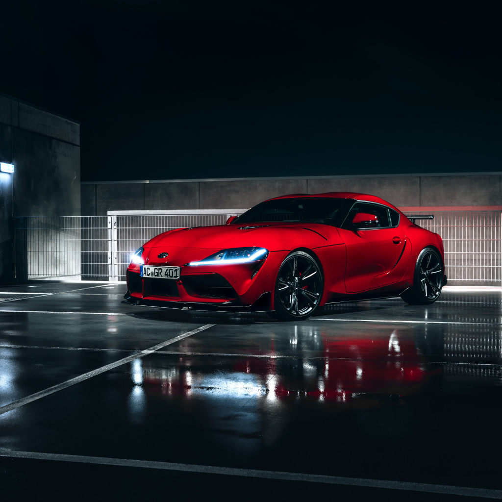 Красный автомобиль Toyota GR Supra AC Schnitzer 2019 года у гаража