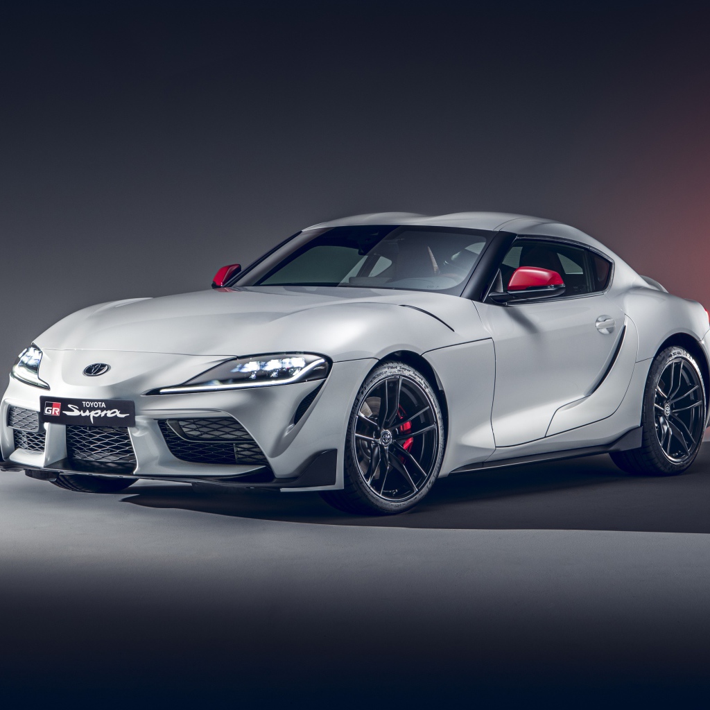 Серебристый автомобиль Toyota GR Supra 2L 2020 года на сером фоне