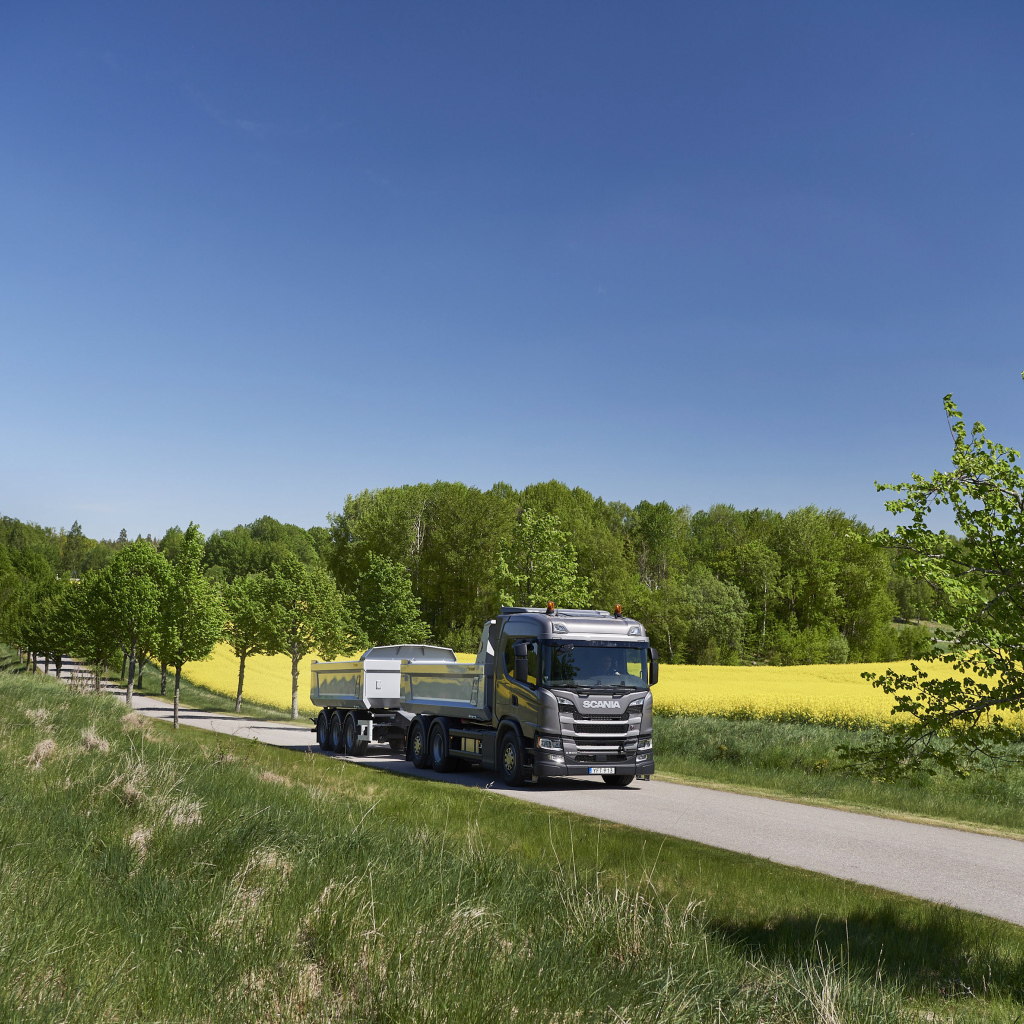 Грузовик Scania Trucks на трассе у поля