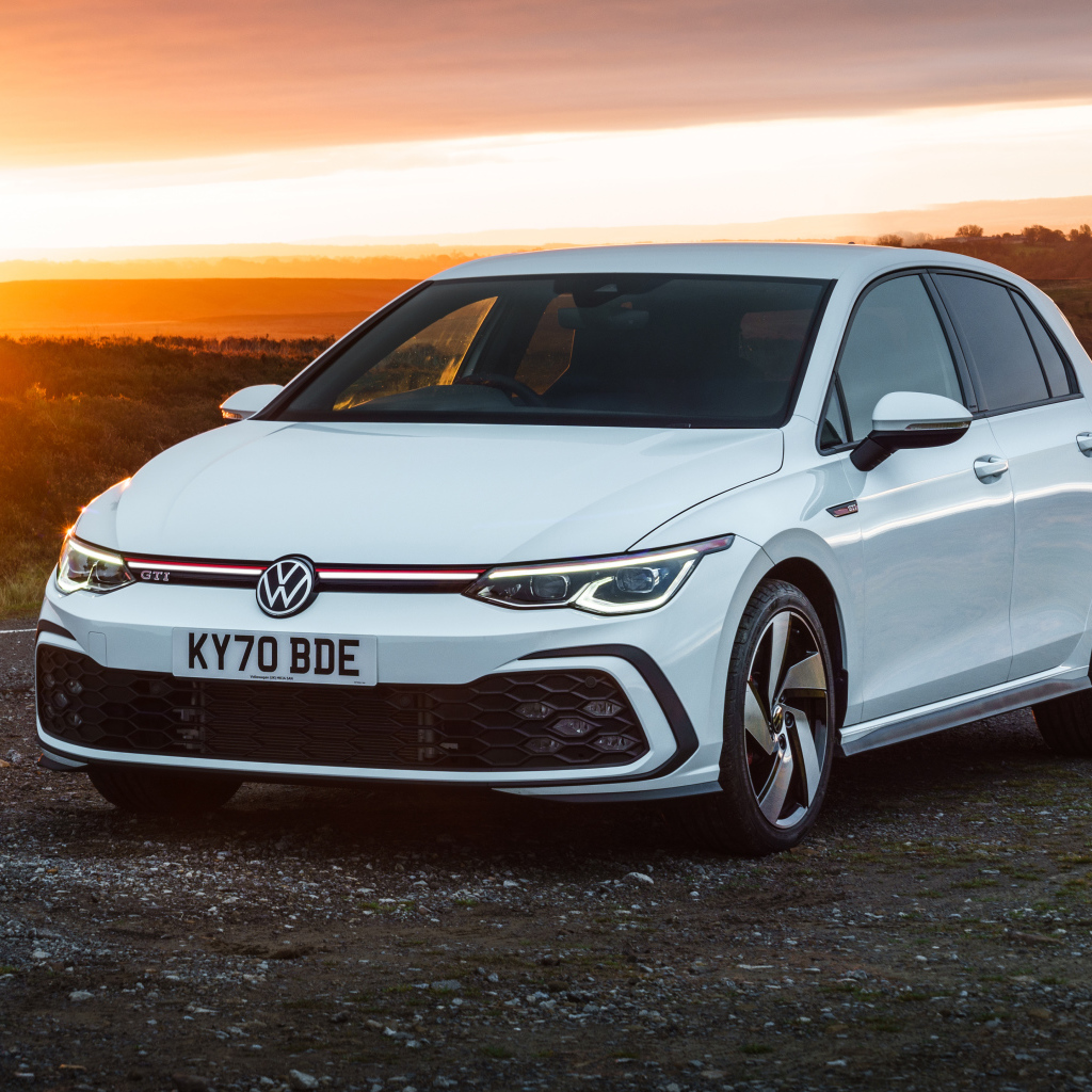 Белый автомобиль Volkswagen Golf GTI 2020 года на закате солнца