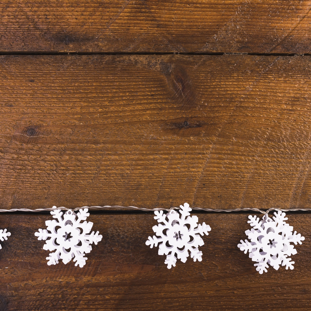 Белые снежинки на деревянном фоне
