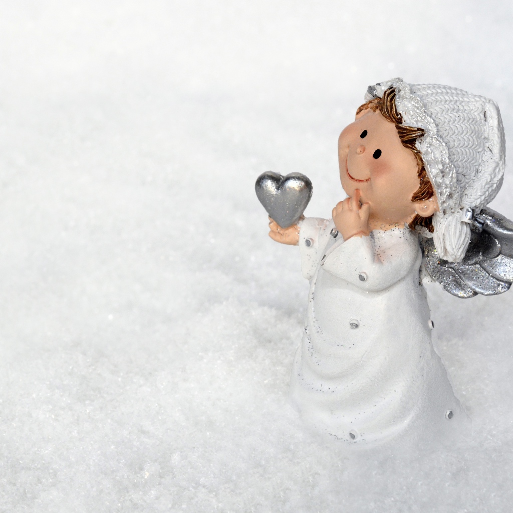 Статуэтка ангела стоит на снегу 
