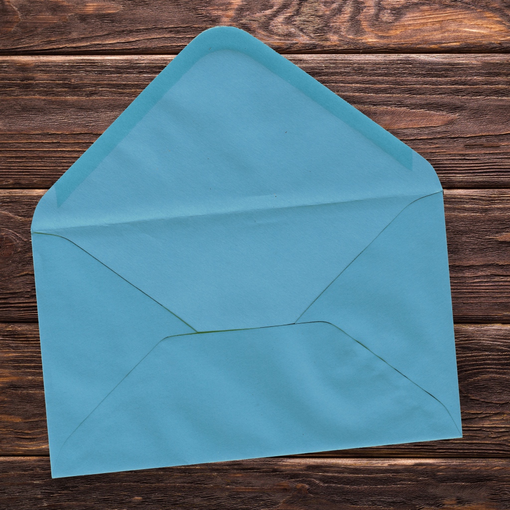 Голубой бумажный конверт на деревянном фоне