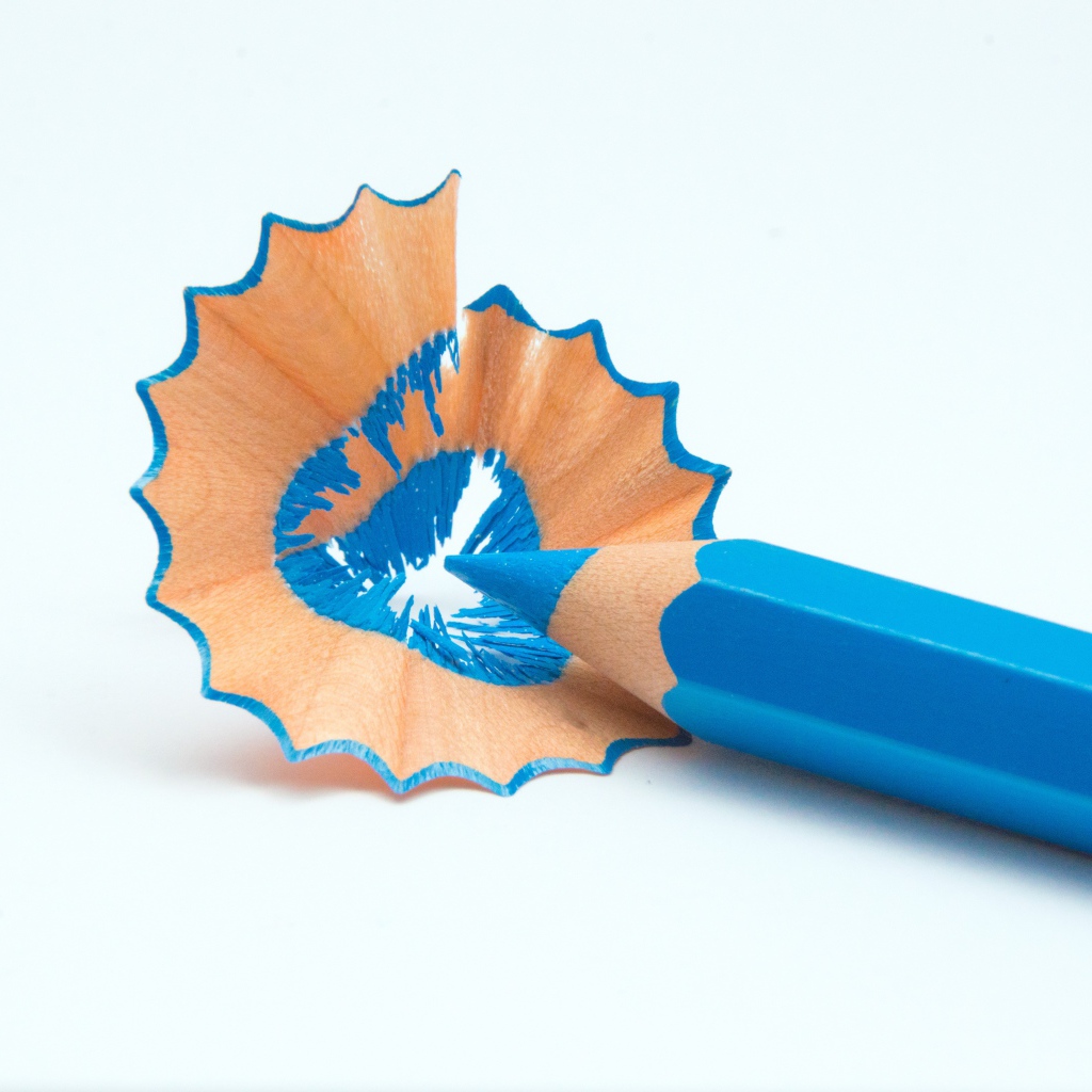 Голубой карандаш со стружкой на белом фоне