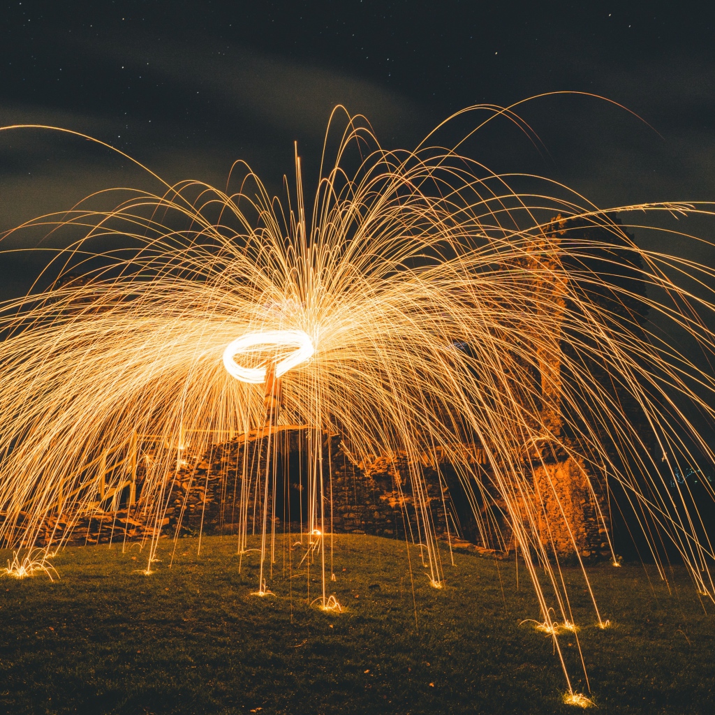 Яркие огненные искры фейерверка на развалинах