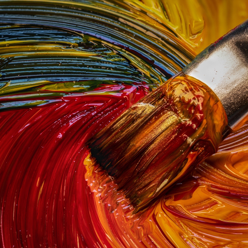 Кисть смешивает краски в палитре 