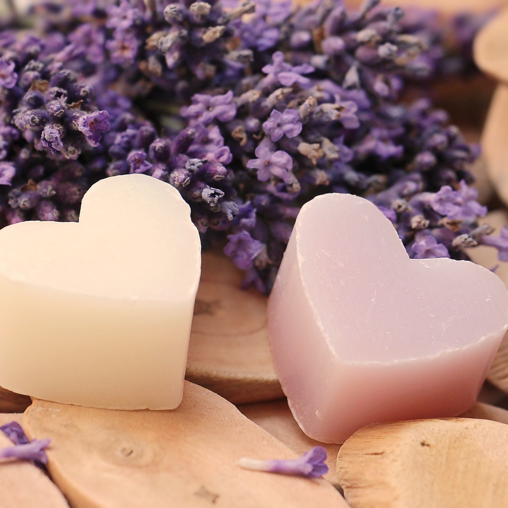 Мыло в форме сердца на столе с цветами лаванды