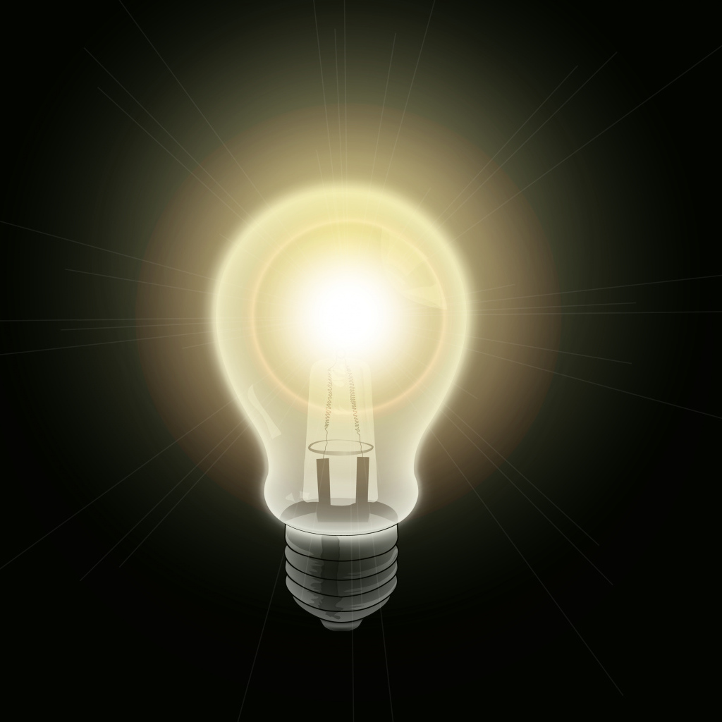 Зажженная лампа накаливания на черном фоне