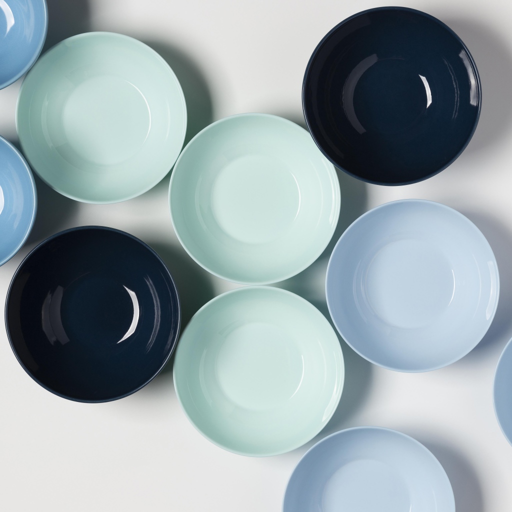 Разноцветные фарфоровые миски на столе 